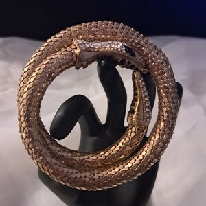 Luxurious Gold Tone Snake Bracelet with Crystal Accents.